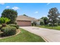 Single-story house with attached garage and well-maintained lawn at 5500 Belle Terre Dr, Leesburg, FL 34748