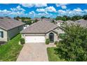 Single-story house with a white garage door and landscaped lawn at 3450 Landing Vw, Tavares, FL 32778