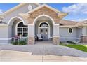 Welcoming front porch with stone accents and seating area at 12764 County Road 223, Oxford, FL 34484