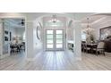 Bright and airy entryway with wood-look tile floors, showcasing views to the living room and dining area at 3457 Lake Diane Rd, Tavares, FL 32778