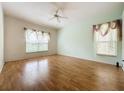 Spacious bedroom with laminate flooring, ceiling fan, and two windows at 2109 Grafton Ave, Clermont, FL 34711