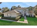 Two-story house with a gray exterior, brown roof, and landscaped yard at 24126 Plymouth Hollow Cir, Sorrento, FL 32776