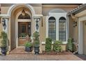 Elegant entryway with arched doorway and landscaping at 9425 San Miguel, Howey In The Hills, FL 34737