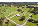 Aerial view of a large property with a house, barns, and fenced pastures at 39400 French Rd, Lady Lake, FL 32159