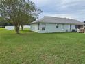 House's backyard features a large green lawn and privacy fence at 36641 Tropical Wind Ln, Grand Island, FL 32735