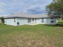 Spacious backyard with grassy lawn and partial view of the house at 36641 Tropical Wind Ln, Grand Island, FL 32735
