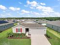 Single-story home with gray siding, red shutters, and a two-car garage at 5120 Tanzanite Dr, Mount Dora, FL 32757