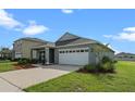 Gray one-story house with white garage door at 1565 Tali Ln, Mount Dora, FL 32757