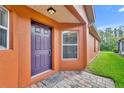 Exterior view of house entrance with purple door and brick walkway at 540 Grand Canal Dr, Kissimmee, FL 34759