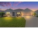 One-story house with light blue siding and a white garage door at dusk at 6692 Newell Loop, The Villages, FL 34762