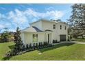 A two-story house with a modern exterior, attached garage, and beautifully landscaped yard at 12332 Basin St, Clermont, FL 34715