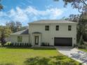 Two-story home with a white exterior, dark garage door, and a well-maintained lawn at 12332 Basin St, Clermont, FL 34715