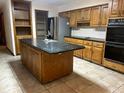 Kitchen featuring an island, wood cabinets, and granite countertops at 4125 S Highway 314A, Ocklawaha, FL 32179