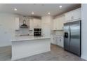 Modern kitchen with white cabinets and island at 3046 Ruby Falls Dr, Deland, FL 32724