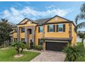 Stunning two-story house with a yellow exterior, brown accents, and a two-car garage at 349 Morning View Dr, Winter Garden, FL 34787