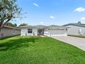 Front yard view of a single story home with gray roof and white exterior at 32857 Timberwood Dr, Leesburg, FL 34748