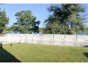 Fenced backyard with a view of a lake and lush green grass at 1681 Strathmore Cir, Mount Dora, FL 32757