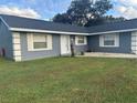 Gray house with white accents, a grassy lawn, and a cactus planter at 192 Villa City Rd, Groveland, FL 34736