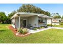 Landscaped manufactured home with carport at 805 Roseapple Ave, The Villages, FL 32159