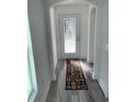 Bright entryway with gray laminate flooring and a patterned rug at 15877 Se 98Th Ct, Summerfield, FL 34491