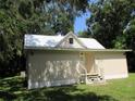 Cute cottage style home with a metal roof and mature trees at 214 W Dade Ave, Bushnell, FL 33513