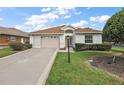 Single story house with a brown roof and a two-car garage at 17549 Se 115Th Terrace Rd, Summerfield, FL 34491