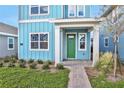 Front entry of light blue home with green door and walkway at 3018 Mirage Pl, St Cloud, FL 34771