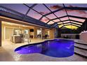 Inviting pool area with a covered lanai, outdoor kitchen, and plenty of seating at 4049 Nostalgia Ter, The Villages, FL 32163