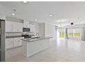 Open kitchen with island, stainless steel appliances, and white cabinets at 1496 Mirabella Cir, Davenport, FL 33897