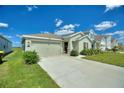 One-story house with a two-car garage, well-maintained lawn, and attractive landscaping at 656 Daring Dr, Davenport, FL 33837