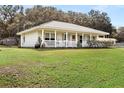 Charming one-story home with metal roof, front porch, and spacious lawn at 218 Ann St, Lady Lake, FL 32159