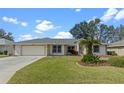 One-story house with attached garage and landscaped yard at 5729 King James Ave, Leesburg, FL 34748
