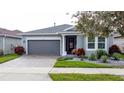 Gray house with a two-car garage and landscaping at 518 Narrow View Ln, Groveland, FL 34736
