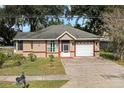 Tan house with brick driveway and landscaping at 919 Patrick St, Kissimmee, FL 34741