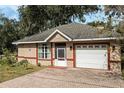 Tan house with brick driveway and landscaping at 919 Patrick St, Kissimmee, FL 34741