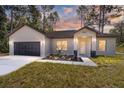 Modern home exterior at dusk with dark brown garage door at 3611 Se 132Nd Pl, Belleview, FL 34420