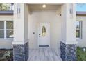 Inviting entryway with modern door and stone accents at 3611 Se 132Nd Pl, Belleview, FL 34420