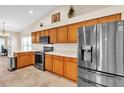 Modern kitchen with stainless steel appliances and wood cabinets at 815 Forest Breeze Path, Leesburg, FL 34748