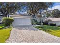 Beautiful home exterior with a paver driveway and landscaping at 8194 Se 177Th Winterthur Loop, The Villages, FL 32162