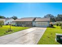 Ranch-style home with a screened porch, mature landscaping, and a two-car garage at 2411 Greenlaw Ct, Leesburg, FL 34788