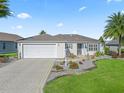Single-story home with a white exterior, landscaped yard, and a two-car garage at 3358 Quail Hollow Ct, The Villages, FL 32163