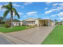 Single-wide manufactured home with carport and palm tree at 1704 Pebble Beach Ln, Lady Lake, FL 32159