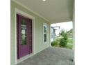Covered front porch with purple door and view of the neighborhood at 9934 Fiddley Aly, Orlando, FL 32827