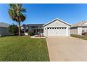 Single-story house with a two-car garage and lush lawn at 1312 Landeros Ln, The Villages, FL 32159