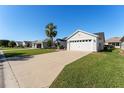 Exterior view of a house with a two-car garage and spacious driveway at 1312 Landeros Ln, The Villages, FL 32159