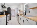 Modern kitchen with white shaker cabinets, butcher block countertops, and stainless steel appliances at 2030 Leisure Dr, Winter Haven, FL 33881