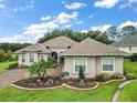 House with a palm tree and manicured landscaping at 5096 Greens Dr, Lady Lake, FL 32159