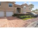 Tan two-story townhome with attached two-car garage and lush landscaping at 5279 Bowline Ct, Oxford, FL 34484