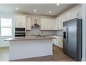 Modern kitchen with white cabinets, stainless steel appliances, and an island at 5085 Grand Teton Ct, Deland, FL 32724