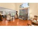 Living room with terracotta tile floors, large windows, and comfortable seating at 1405 Hilltop Dr, Mount Dora, FL 32757